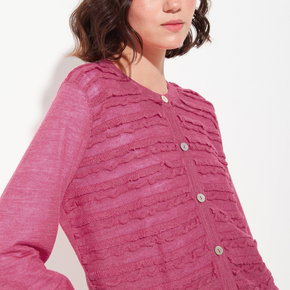 Close-up of a pink textured cardigan worn by a person on a white background