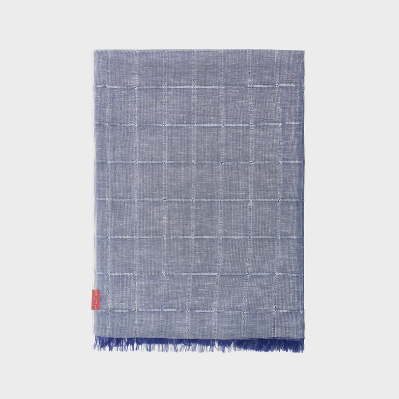 Blue checkered shawl with frayed edges on a light gray background