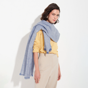 Woman wearing a blue scarf and yellow top on a white background