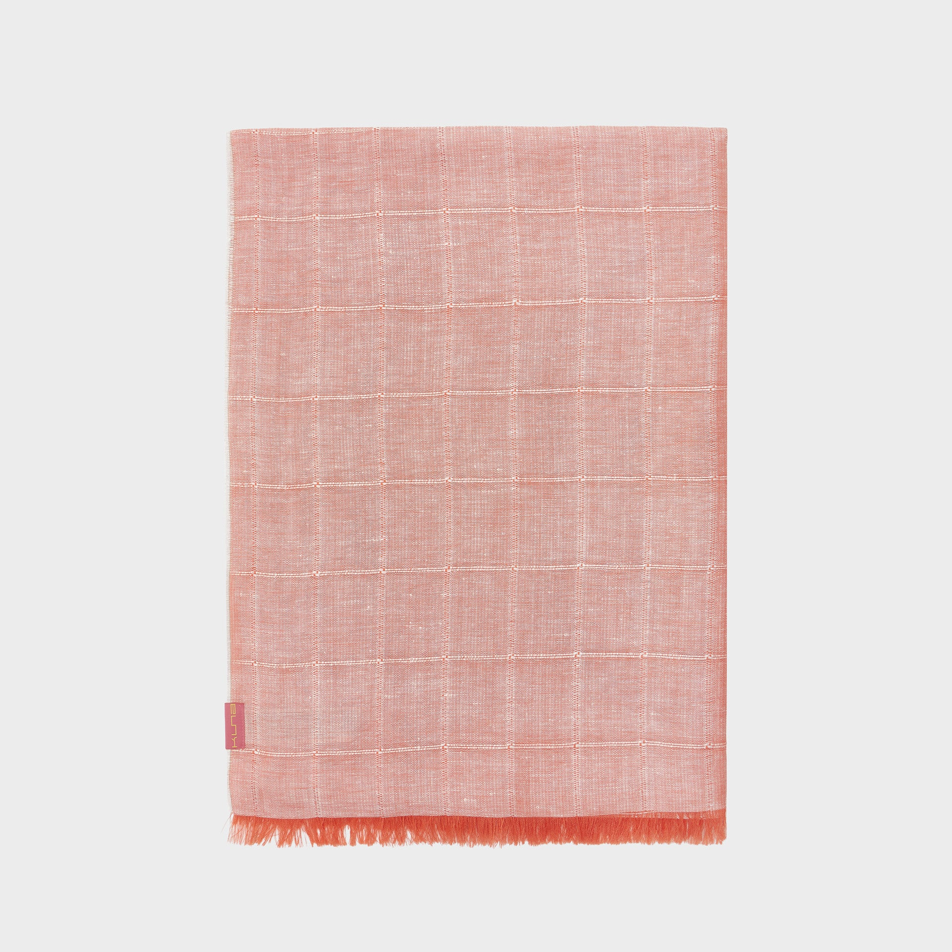 Orange woven shawl with a fringe border on a light gray background