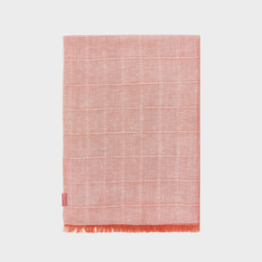 Orange woven shawl with a fringe border on a light gray background