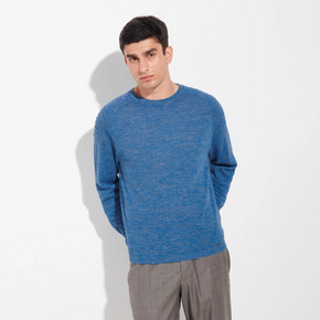 Man wearing a blue sweater and gray pants on a white background