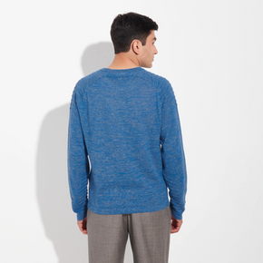 Man wearing a blue sweater and gray pants on a white background
