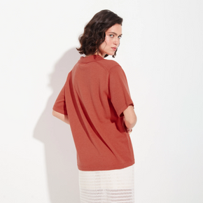 Woman wearing a rust-colored shirt on a white background