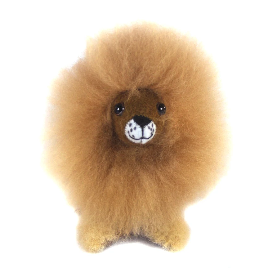 A fluffy lion plush toy with a golden-brown mane, dark brown face, and a white muzzle with black spots, photographed against a plain white background.