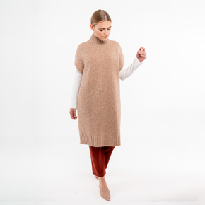 Front, full-length view of beige alpaca poncho with turtleneck, displaying soft alpaca material.
