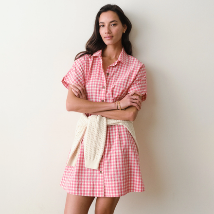 Woman wearing a pink gingham dress with a white background