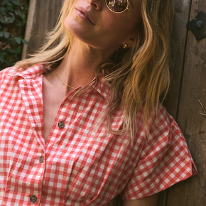 Woman wearing a red and white checkered shirt against a wooden background