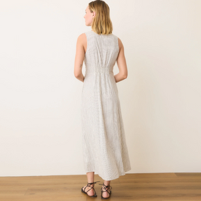 Woman wearing a white sleeveless dress against a plain background