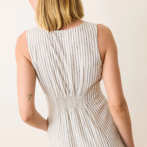 Woman wearing a sleeveless striped dress on a plain background