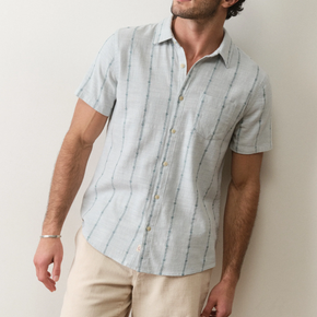 Man wearing a light blue striped shirt against a plain background