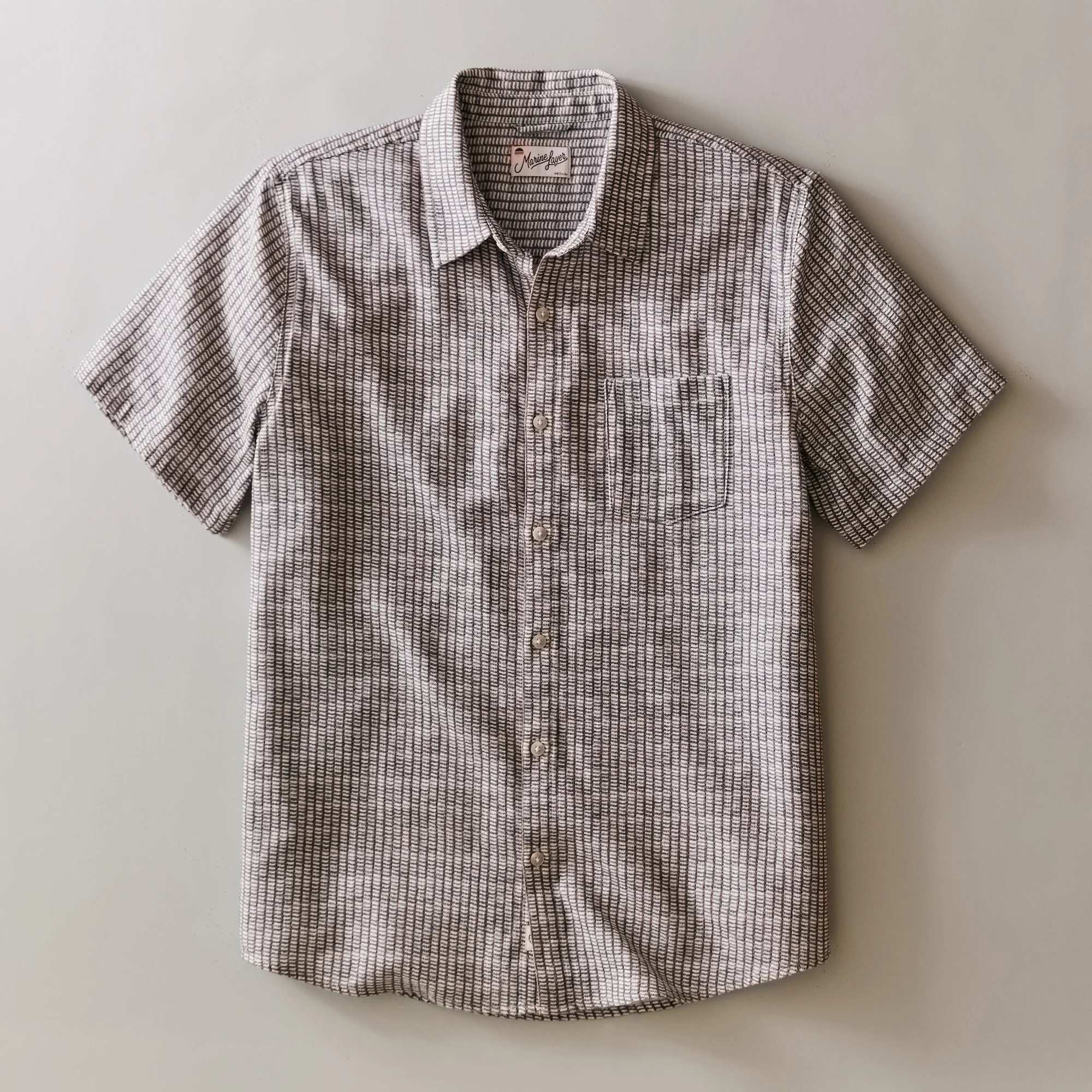 Plaid short-sleeve shirt on a light gray background