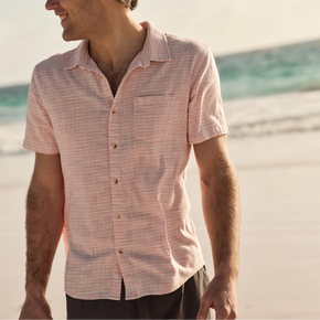 Man wearing a pink checkered shirt on a beach