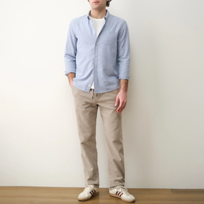 Man wearing a light blue button down and tan pants