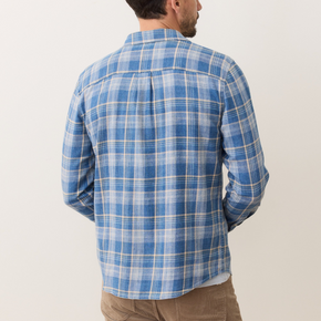 Man wearing a blue plaid shirt against a white background