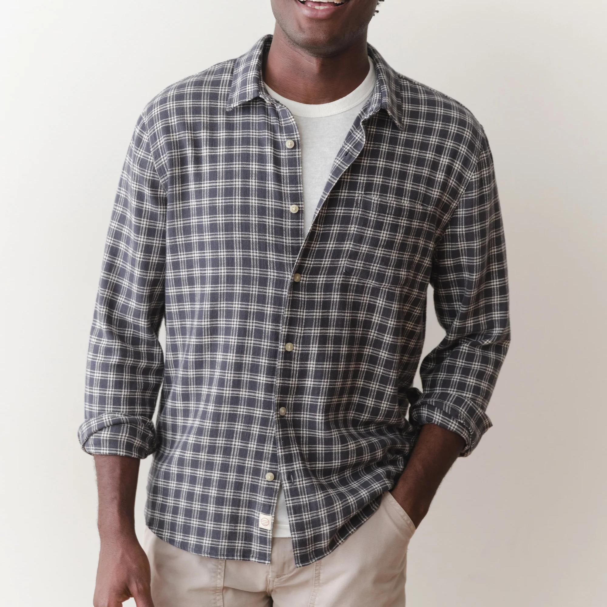 Man wearing a plaid shirt against a plain background