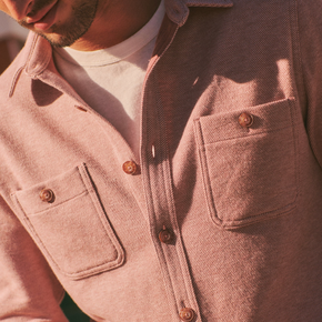 Close-up of a person wearing a pink jacket with button details.