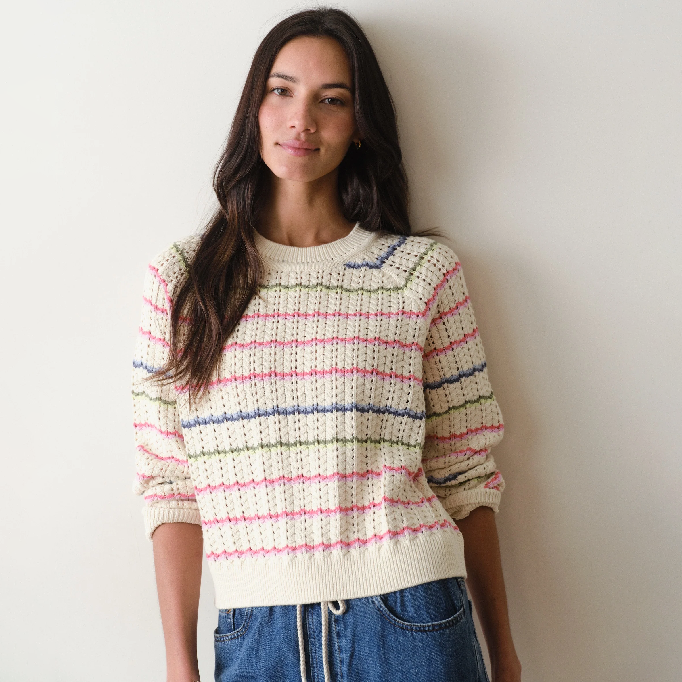 Woman wearing a striped sweater against a plain background