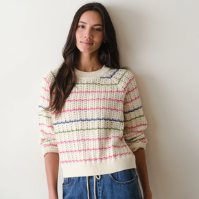 Woman wearing a striped sweater against a plain background