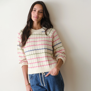 Woman wearing a striped sweater with a plain background