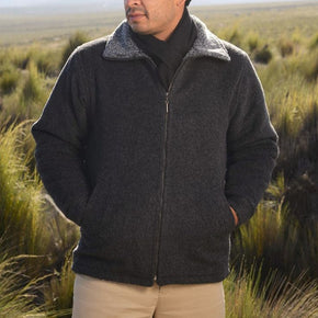 Man wearing a dark jacket in a grassy field