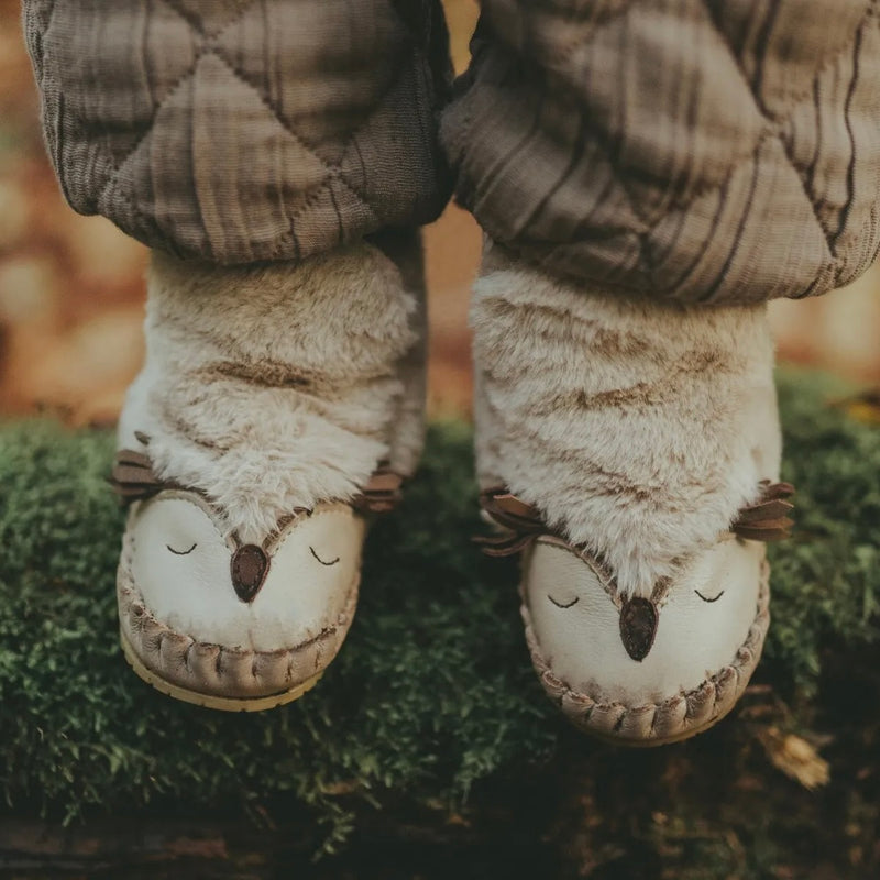 Donsje Owl Kapi Classic Lining Boots - child wearing leather and faux fur boots with owl features on a mossy background