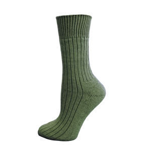 Green sock on a wooden block with a white background