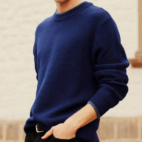 Man wearing a blue sweater with a neutral background