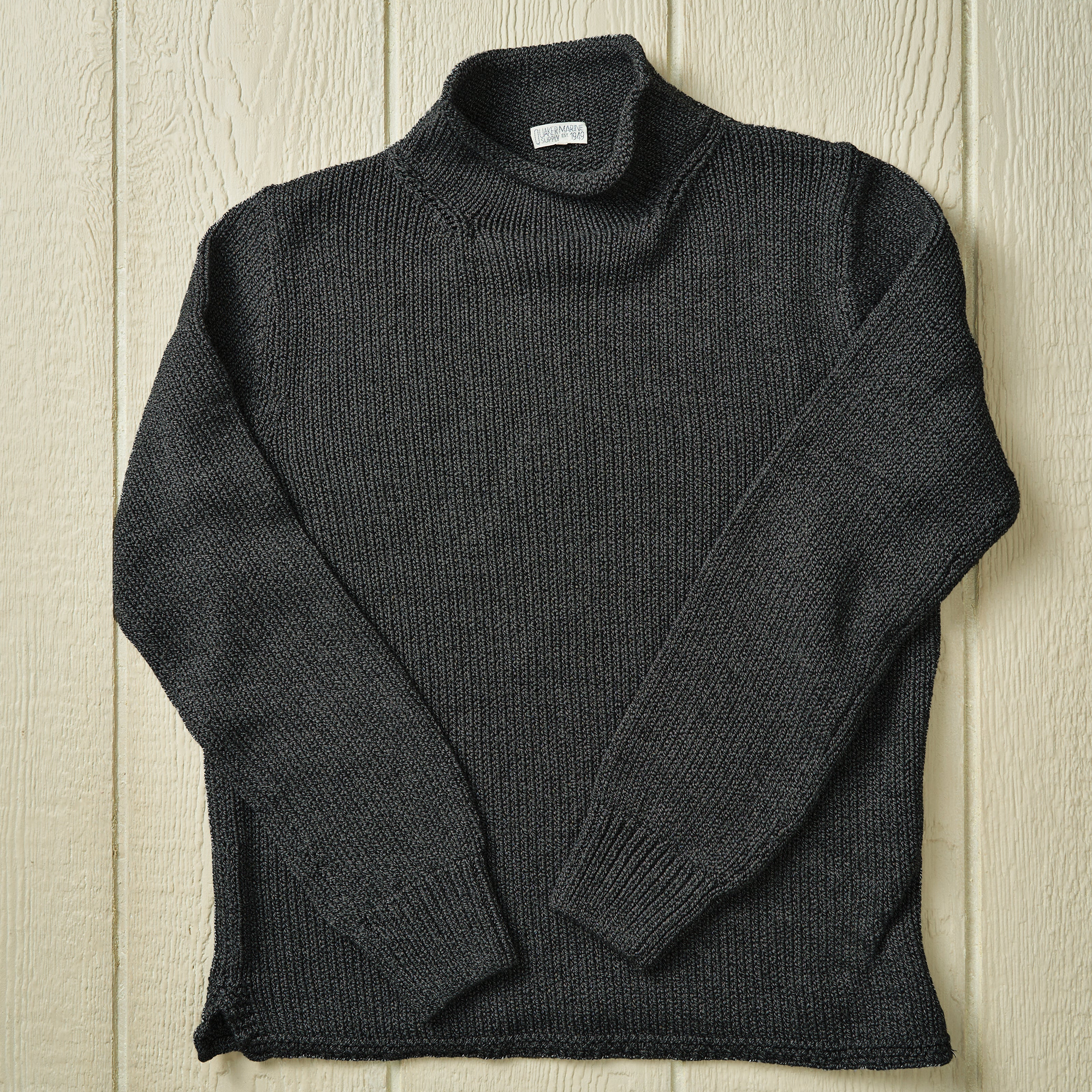 Charcoal grey sweater on a neutral background.