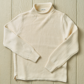 White knit sweater on a neutral background.