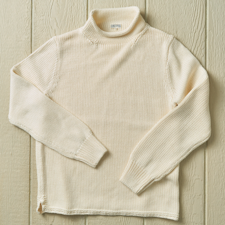 White knit sweater on a neutral background.