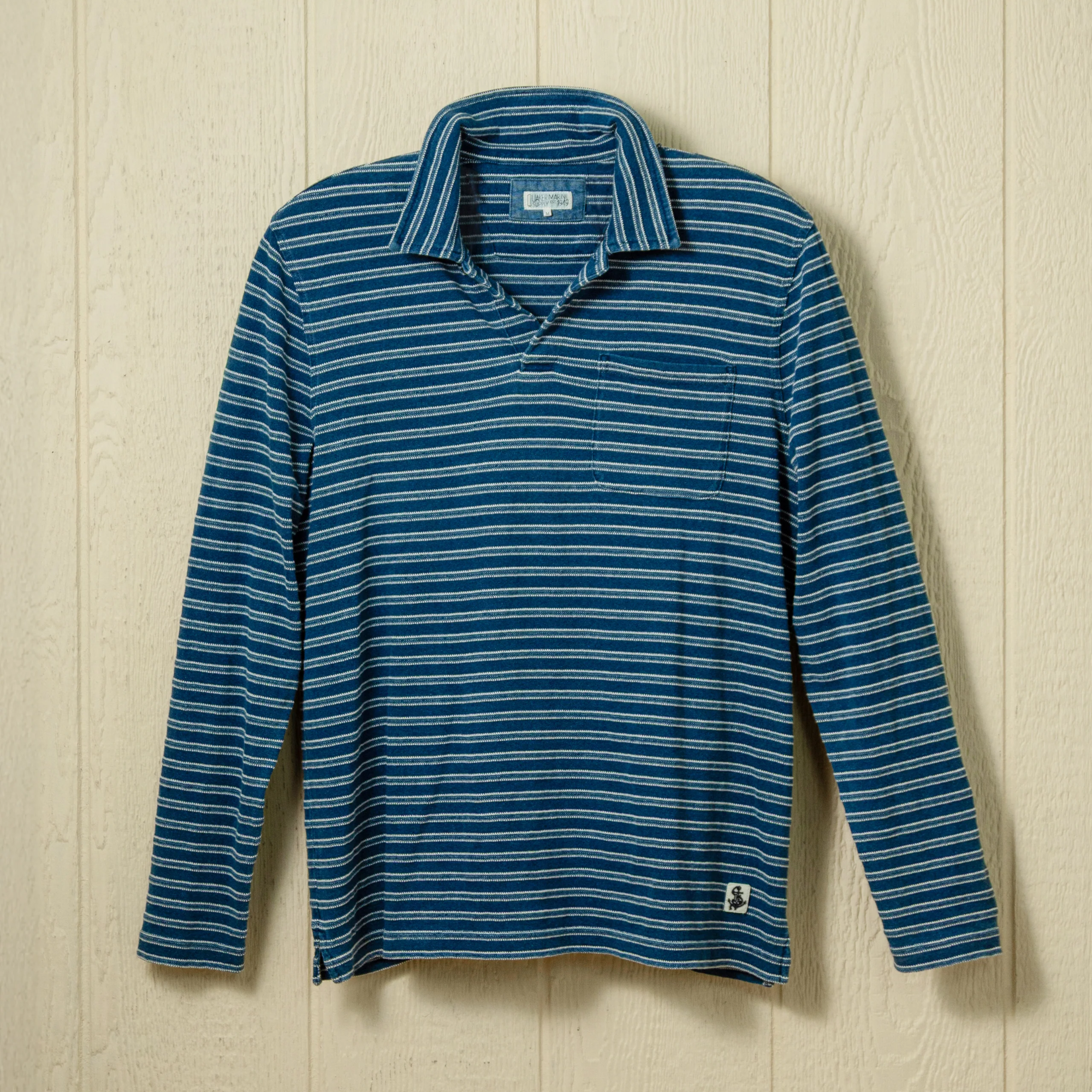 Blue striped long sleeve polo on a neutral background.