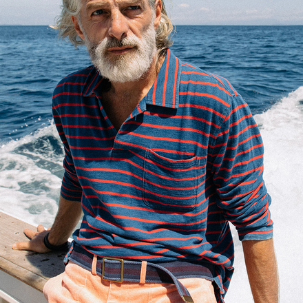 Man wearing blue and red striped long sleeve polo.