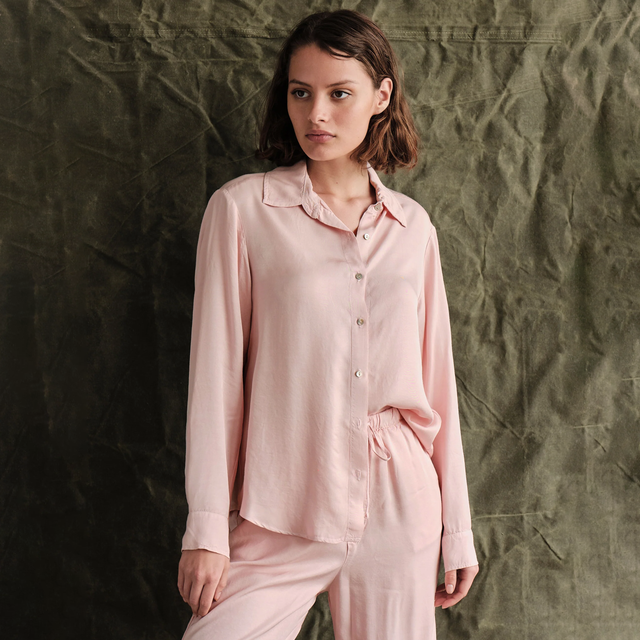 Sundry Button Down Shirt - model wearing light pink button down shirt in front of a green background