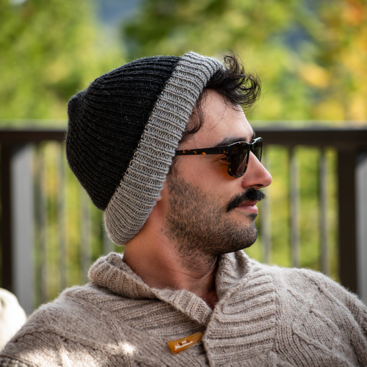 Man wearing the reversible double-knit baby alpaca beanie in charcoal and grey