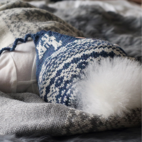 Baby wrapped in a blanket with blue mittens and socks