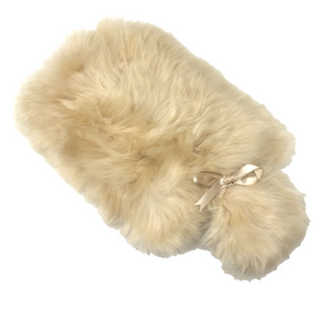 Beige fur hot water bottle with a bow on a white background