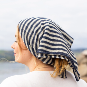 Woman wearing a blue and white striped headscarf with a blurred natural background