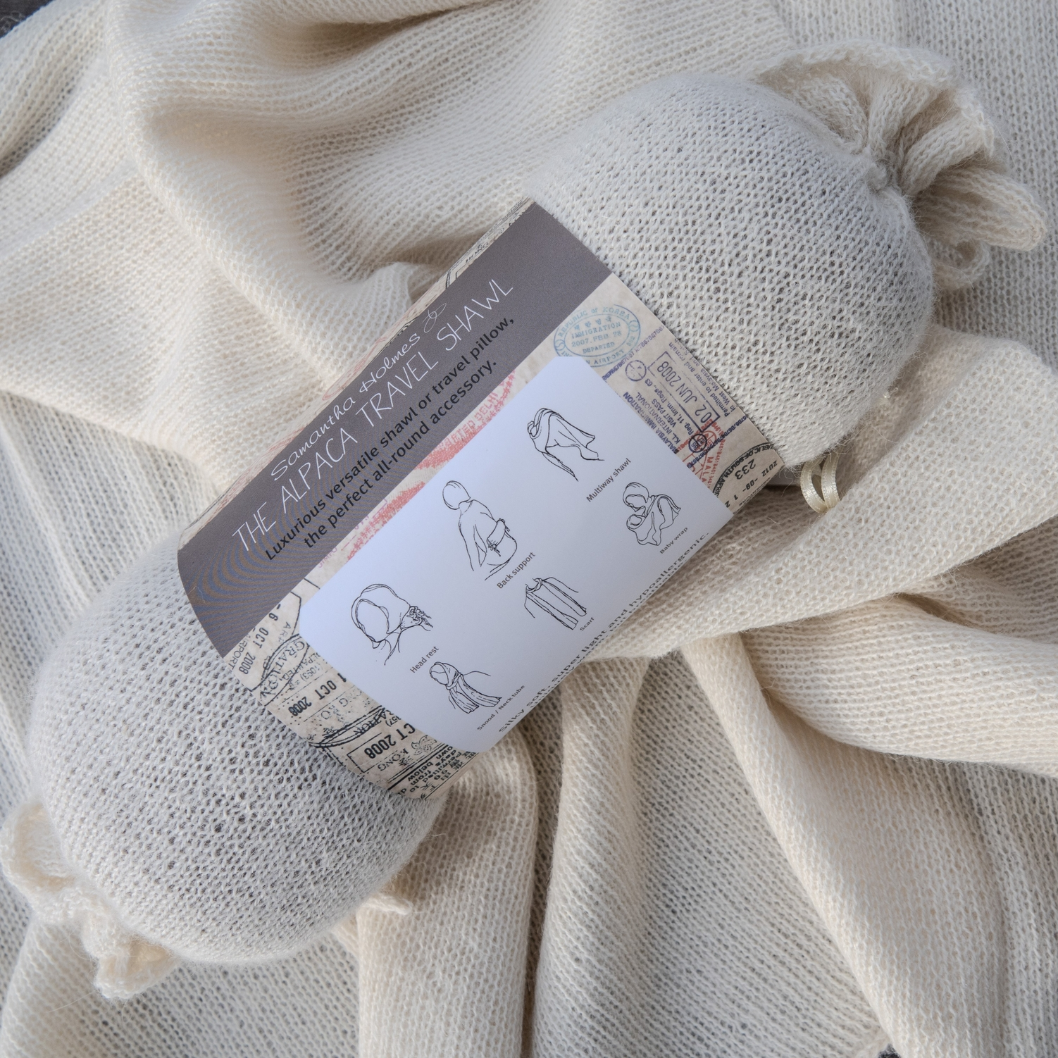 Alpaca travel shawl with label on a textured fabric background