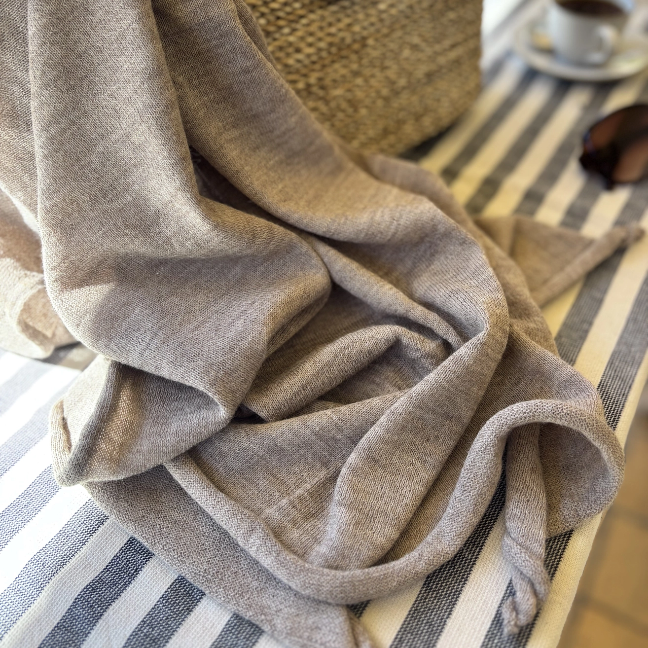 Beige textured wrap draped over a striped surface