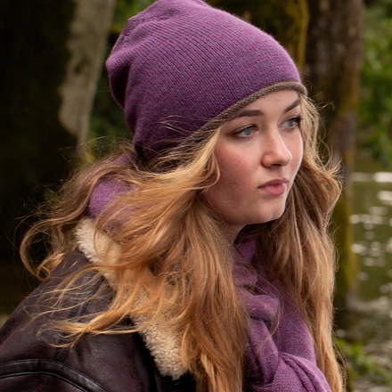 Woman wearing a purple beanie and scarf outdoors