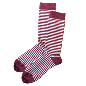 Pair of maroon and white striped socks on a wooden surface