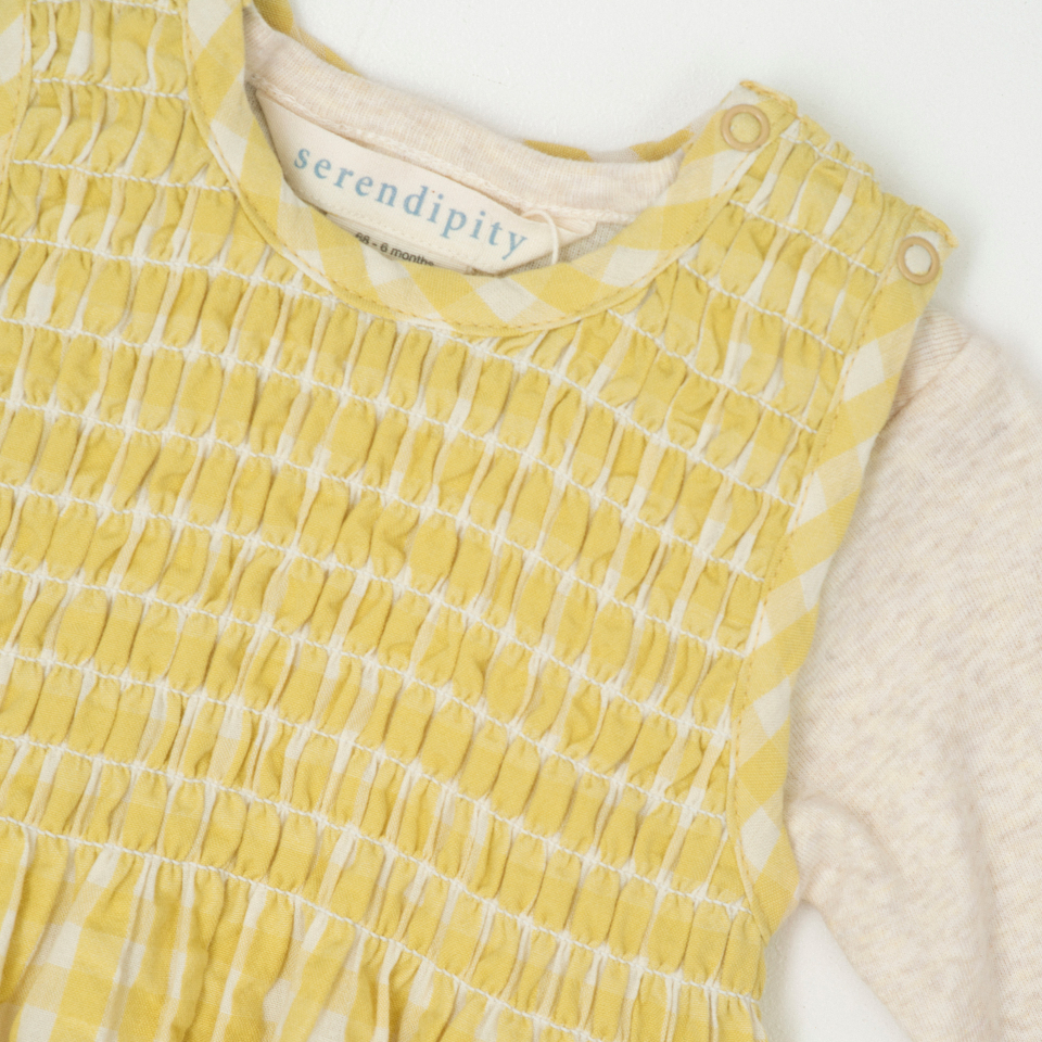 Yellow checkered romper with 'serendipity' label on a white background