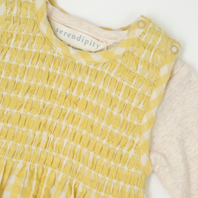 Yellow checkered romper with 'serendipity' label on a white background