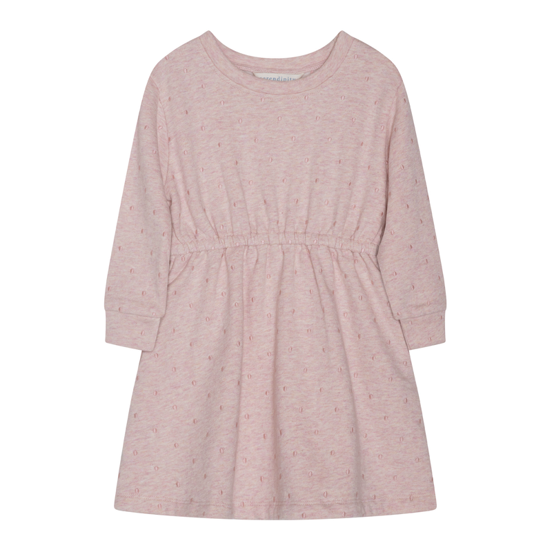 A light pink long-sleeve dress for toddlers, featuring a subtle all-over pattern of small embroidered letters and a gathered elastic waist, shown against a plain white background.