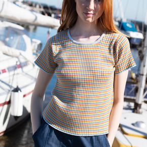 Woman wearing a colorful striped shirt standing by boats