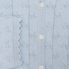 Close-up of a light blue textured sweater with buttons