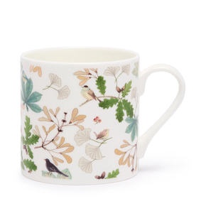Mug with nature-themed design featuring leaves and birds on a white background