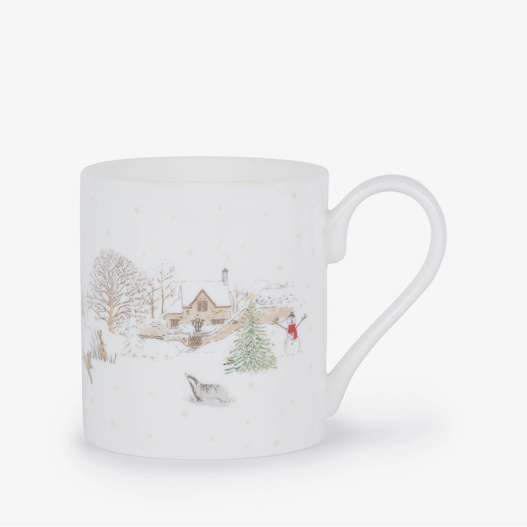 Mug with a winter scene design featuring a house, trees, and a snowman on a white background