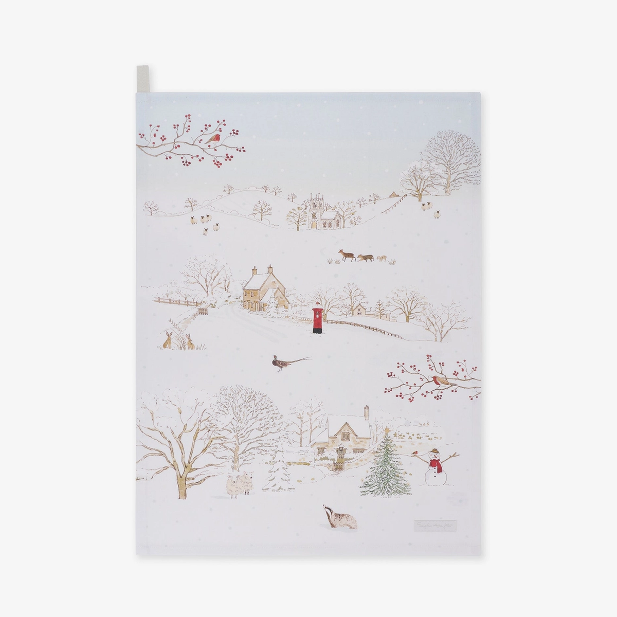 Tea towel featuring a whimsical winter village scene with snow-covered trees, small houses, a lighthouse, birds, and a few figures, shown against a plain light background.
